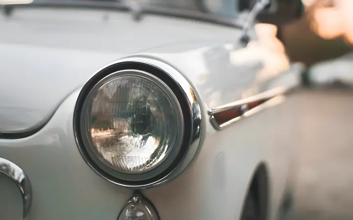 Balto automobilio žibintas ir blizgus sparnas
